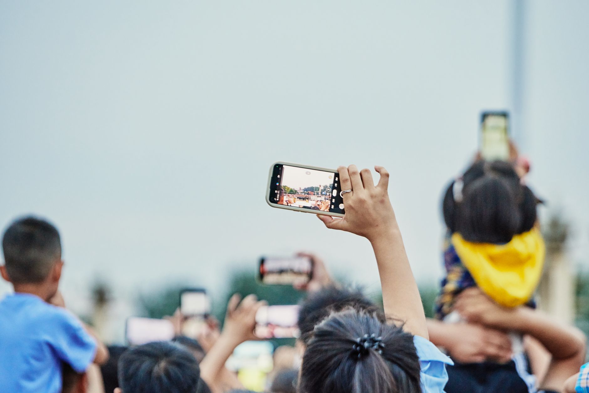 Person scrolling a social media feed on a smartphone with financial tickers visible