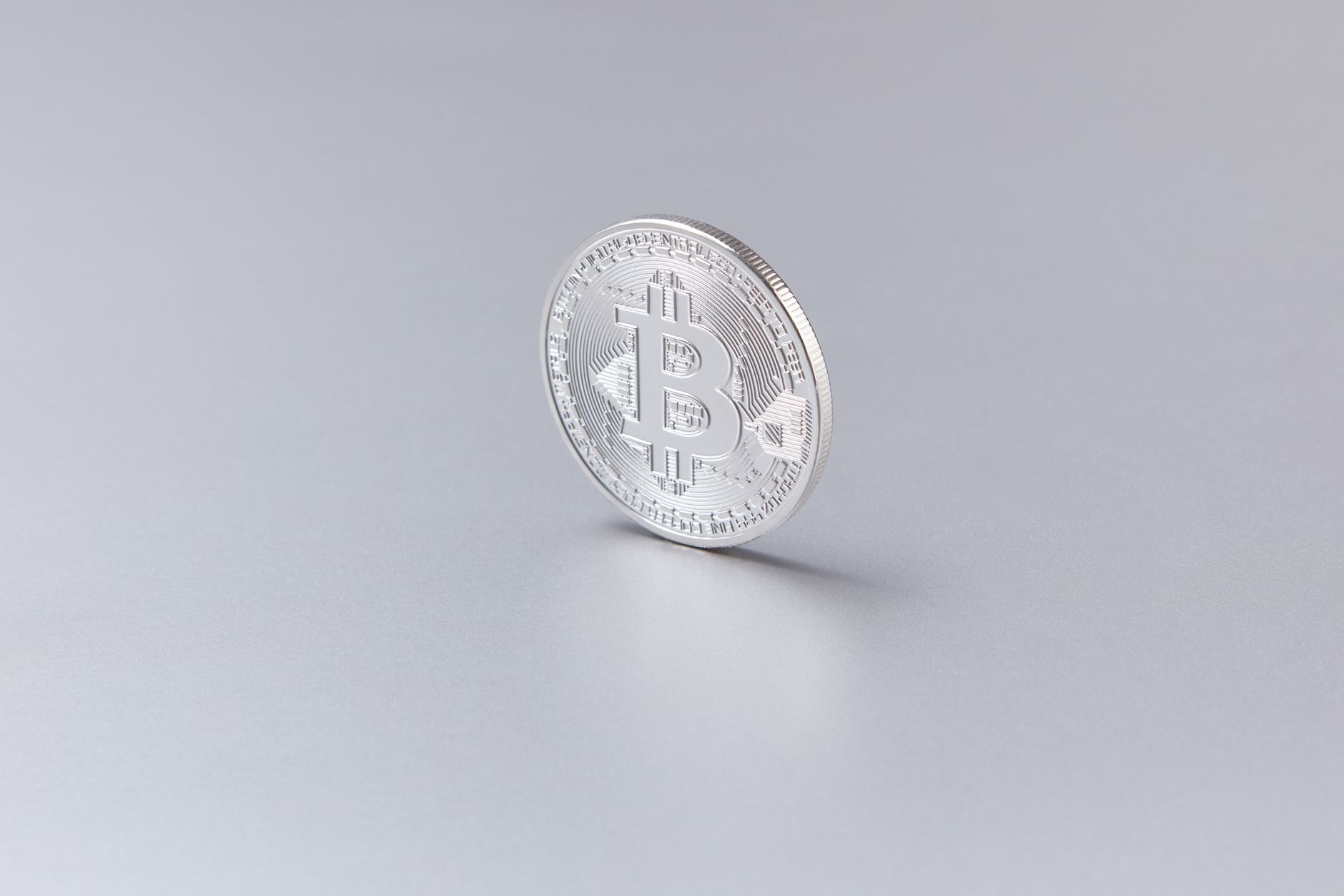 Bitcoin coin resting on financial documents representing cryptocurrency investment