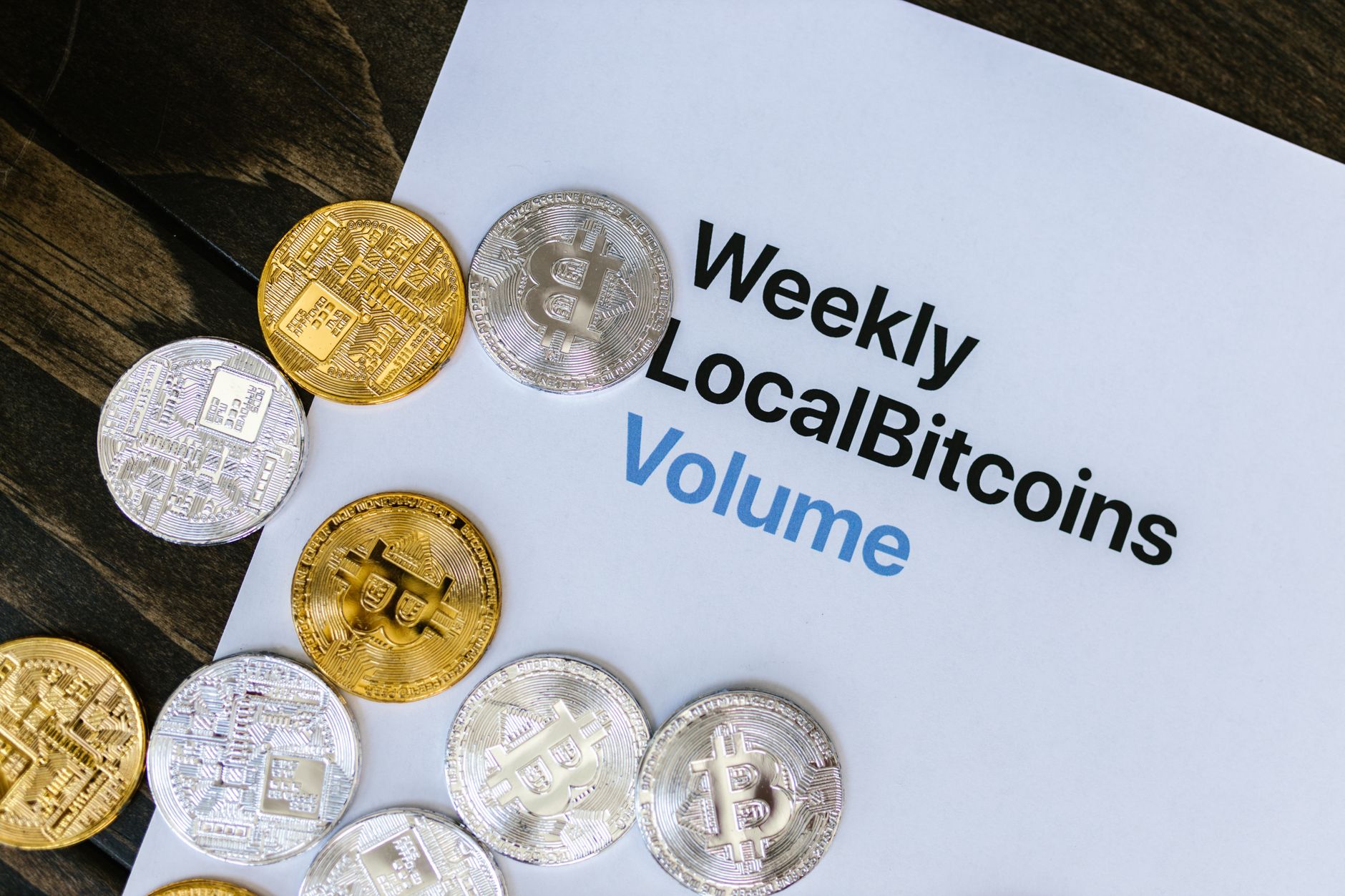Physical crypto coin tokens arranged on a reflective surface representing digital assets