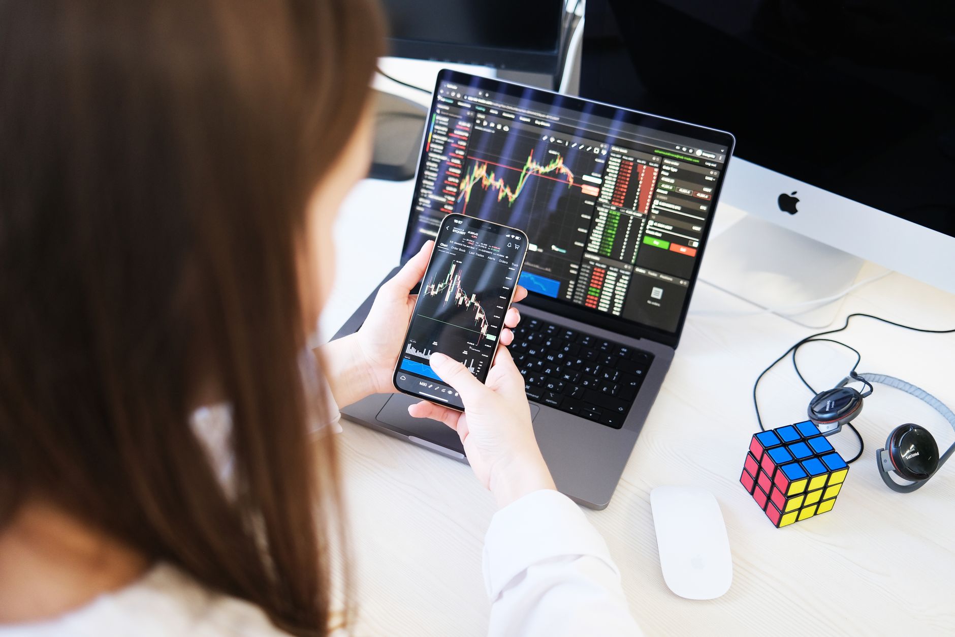 Professional reviewing cryptocurrency exchange data on multiple monitors
